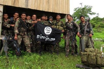 Soldados filipinos con una bandera capturda del EI.