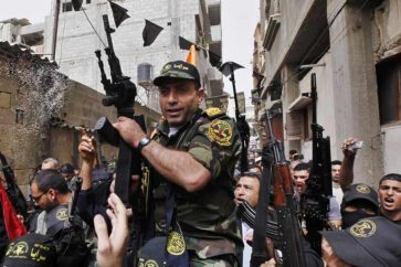 Freed Palestinian prisoner Ibrahim Baroud holds a gun as he carried on the shoulders of Islamic Jihad militants through crowds of people, as he arrives at his home in the northern Gaza Strip April 8, 2013. Baroud, who was convicted of his affiliation with the armed group of Islamic Jihad and for carrying out armed attacks against Israel, was released on Monday after serving 27 years in an Israeli jail, according to media reports.  REUTERS/Mohammed Salem (GAZA - Tags: POLITICS TPX IMAGES OF THE DAY) - RTXYD67