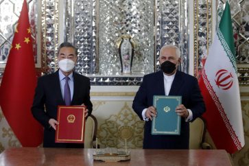 Iranian Foreign Minister Mohammad Javad Zarif (R) and his Chinese counterpart Wang Yi, pose for a picture after signing an agreement in the capital Tehran, on March 27, 2021. - Iran and China signed what state television called a "25-year strategic cooperation pact" on today as the US rivals move closer together.
The agreement, which has been kept almost entirely under wraps, was signed by the two countries' foreign ministers, Mohammad Javad Zarif and Wang Yi, an AFP correspondent reported. (Photo by - / AFP)